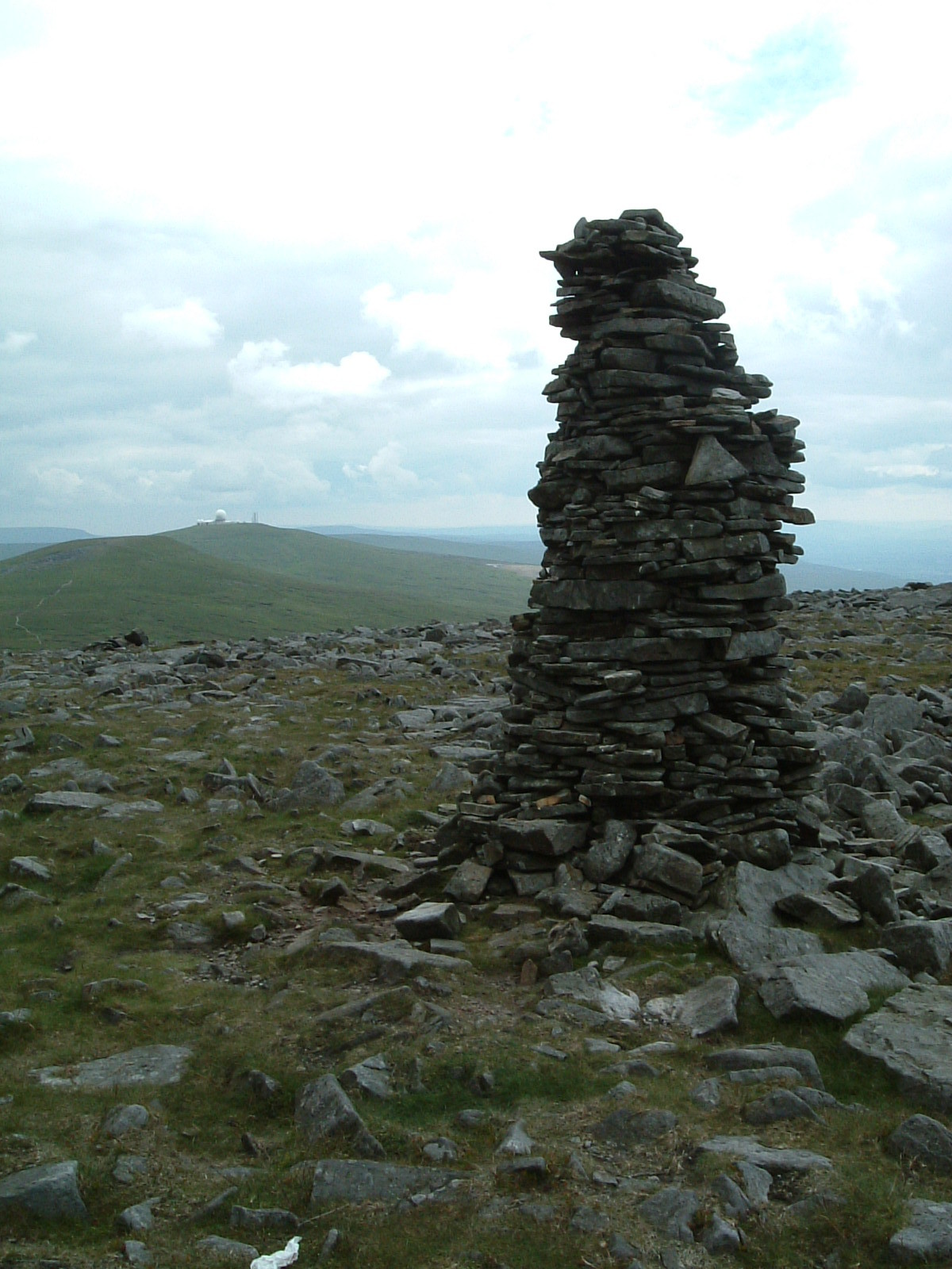 A cairn on the flanks of Cross Fell with Great Dun Fell's radar station in the background