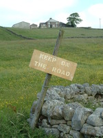 A sign saying 'Keep on the Road'