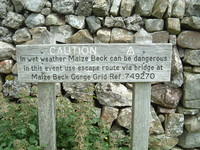 A sign warning that Maize Beck can flood