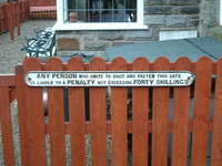 A sign on a gate saying the charge for not shutting it is 40 shillings