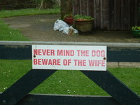 A sign saying 'Never Mind the Dog, Beware of the Wife'