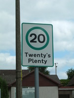A speed limit sign saying 'Twenty's Plenty'