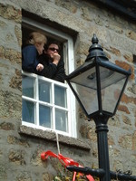 A couple peering from a window in Helston