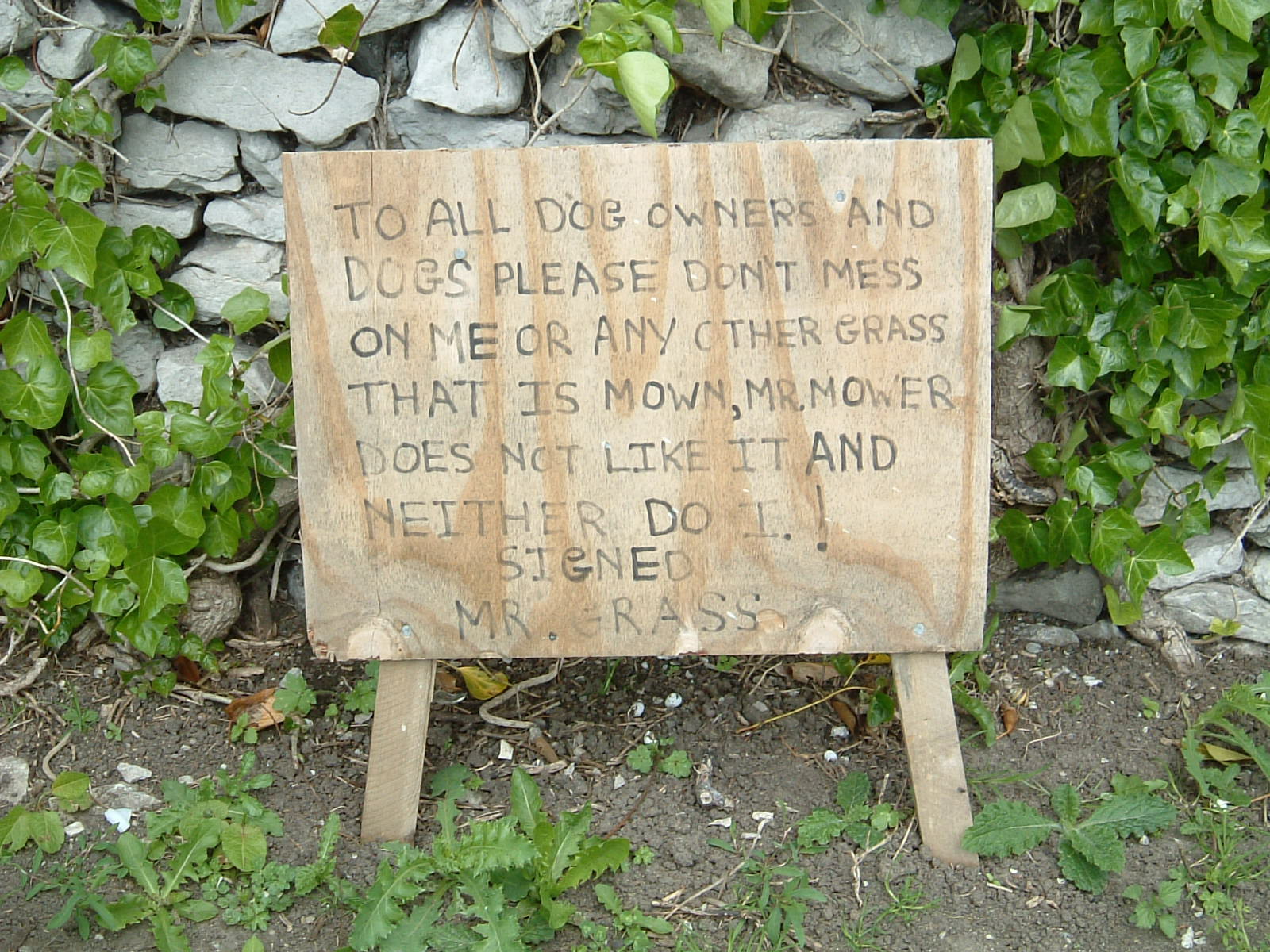 A sign asking people not to let their dogs foul the grass